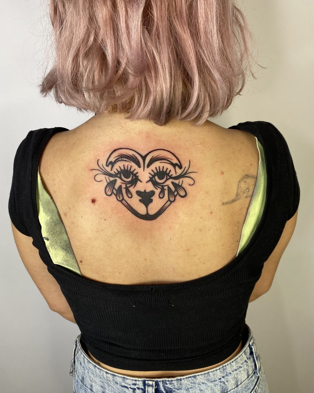 Ornate moth with a dagger through its body, tattooed on a thigh